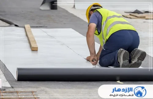 عامل يثبت لفائف العزل المائي (الممبرين) بالسقف باستخدام موقد التسخين.