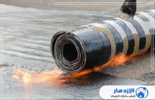 لفة من العزل المائي يجري تسخينها باستخدام موقد لهب لتثبيتها على السطح