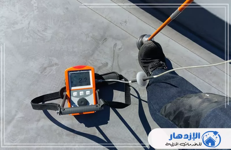 أفضل شركة كشف تسربات المياه في ام القيوين 0505587508 الإزدهار شخص يقوم بقياس درجة حرارة سطح خرساني بواسطة مقياس رقمي.