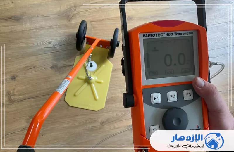 كشف تسريبات المياه للأسطح بأم القيوين 0505587508 الإزدهار شخص يمسك بجهاز محمول بشاشة رقمية لفحص تسريبات المياه على الأسطح في أم القيوين.