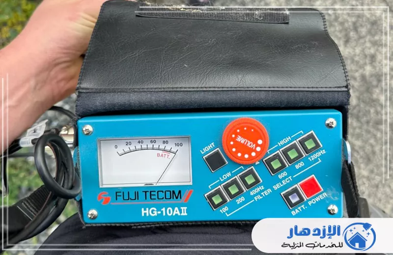 سباك كشف تسربات مياه في ام القيوين 0505587508 الإزدهار فرد يستخدم جهازًا محمولًا بشاشة رقمية لتحديد تسريبات المياه في أم القيوين.