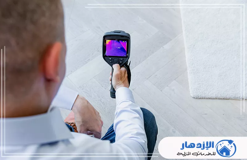 كشف تسربات المياه في ام القيوين 0505587508 الإزدهار رجل يتحقق من درجة الحرارة باستخدام كاميرا حرارية لكشف تسربات المياه في أم القيوين.