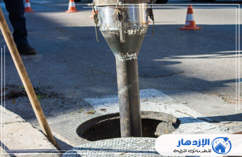 تنظيف مجاري رأس الخيمة 0505587508 الازدهار رجل يقف بجانب أنبوب معدني، يبدو أنه يعمل في مجال تسليك المجاري.